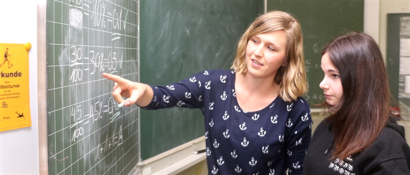 Eine Lehrerin hilft einer Teenagerin bei Mathe