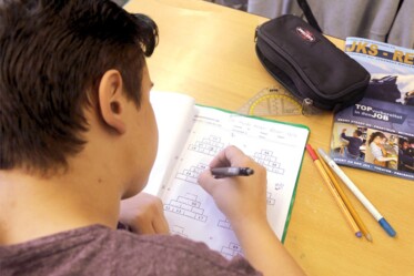 Ein Werkrealschüler schreibt in sein Arbeitsheft