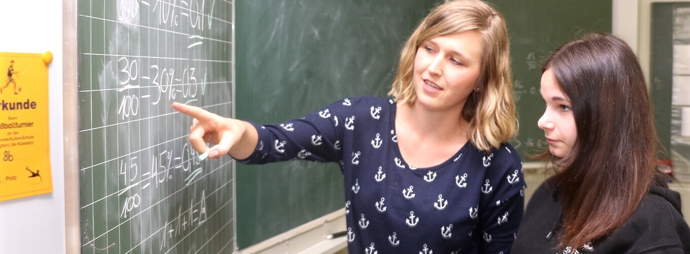 Eine Lehrerin hilft einer Teenagerin bei Mathe